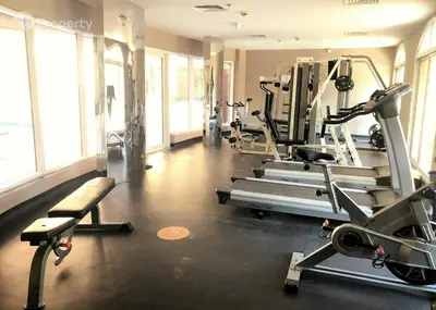 a gym with several tread machines in a room at Luxury 2BR Haven with Expansive Terrace and Elegance in Dubai