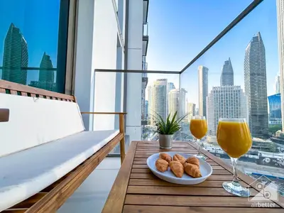 a table with a plate of food and two glasses of orange juice at Luxury 4BR Apartment at Burj Crown I Balcony Views in Dubai
