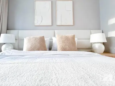 a bedroom with a white bed with two lamps at Luxury 4BR Apartment at Burj Crown I Balcony Views in Dubai