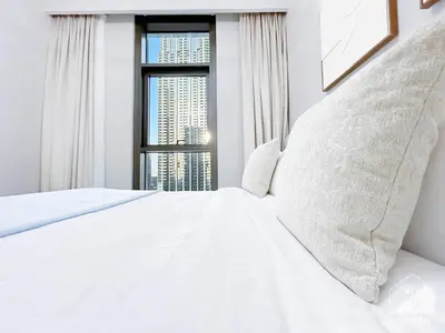 a bedroom with a white bed with a window at Luxury 4BR Apartment at Burj Crown I Balcony Views in Dubai