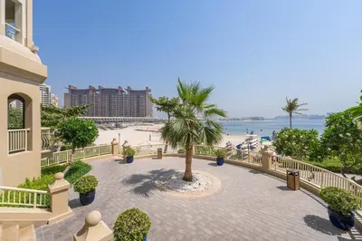 a view of the beach from the balcony of a resort at Breathtaking 1BR Sea-View Palm Apt Beach & Pool in Dubai