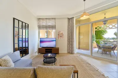 a living room with a couch and a tv at Breathtaking 1BR Sea-View Palm Apt Beach & Pool in Dubai