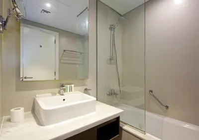 a white bathroom with a sink and a shower at Elegant Studio in Business bay Near Dubai Mall in Dubai