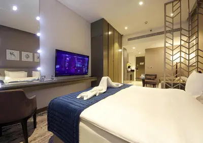 a bedroom with a large bed and a tv at Elegant Studio in Business bay Near Dubai Mall in Dubai