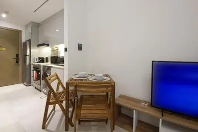 a living room with a table and a tv and a kitchen at Modern Studio Stay in Business Bay Near Dubai Mall in Dubai