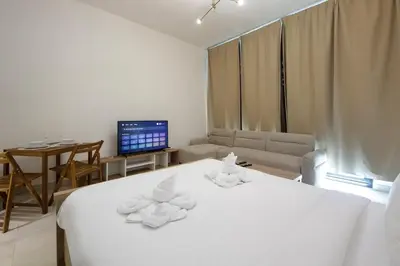 a bedroom with a white bed with towels on it at Modern Studio Stay in Business Bay Near Dubai Mall in Dubai