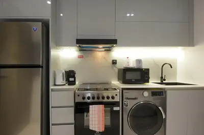 a kitchen with a stove and a refrigerator at Modern Studio Stay in Business Bay Near Dubai Mall in Dubai