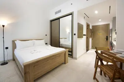 a bedroom with a large bed and a dining room at Modern Studio Stay in Business Bay Near Dubai Mall in Dubai