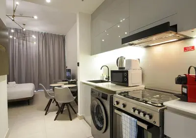 a kitchen with a stove top oven next to a room at Elegant Studio in Binghatti Canal Near Dubai Mall in Dubai