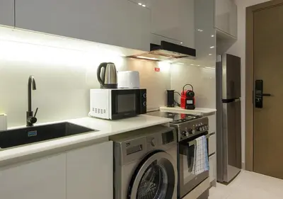 a kitchen with a washing machine and a microwave at Elegant Studio in Binghatti Canal Near Dubai Mall in Dubai