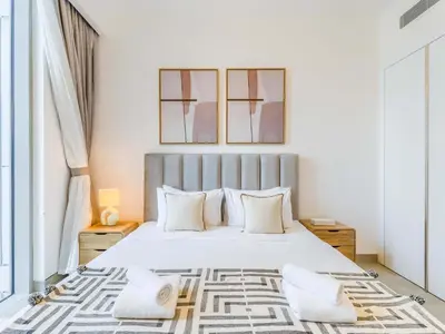 a bedroom with a large white bed with white pillows at TRPS - Luma 22, Jumeirah Village Circle - Chic 1BR Modern Sanctuary in Dubai
