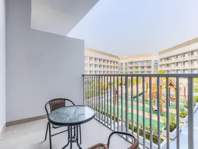 a balcony with a table and chairs and a view at TRPS - Luma 22, Jumeirah Village Circle - Chic 1BR Modern Sanctuary in Dubai