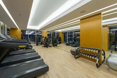 a gym with treadmills and machines in a room at TRPS - Luma 22, Jumeirah Village Circle - Chic 1BR Modern Sanctuary in Dubai