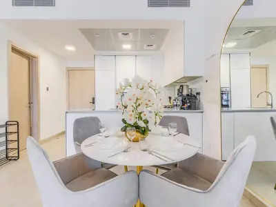a white dining room with a white table and chairs at TRPS - Luma 22, Jumeirah Village Circle - Chic 1BR Modern Sanctuary in Dubai