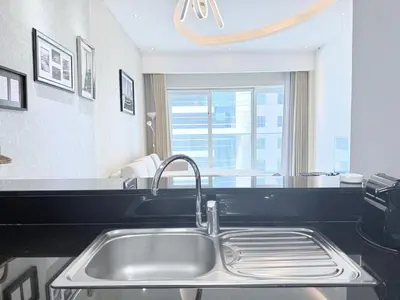 a kitchen with a stainless steel sink and a window at Premium Stay - Damac Heights 1BR in Dubai