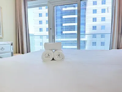 two towels sitting on top of a bed with a window at Premium Stay - Damac Heights 1BR in Dubai