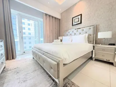 a bedroom with a large white bed and a window at Premium Stay - Damac Heights 1BR in Dubai