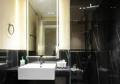 a bathroom with a sink and a shower and a mirror at Chic Studio Apartment Binghatti Canal Business Bay in Dubai