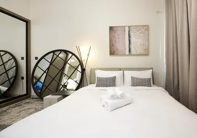 a bedroom with a large white bed with towels on it at Chic Studio Apartment Binghatti Canal Business Bay in Dubai