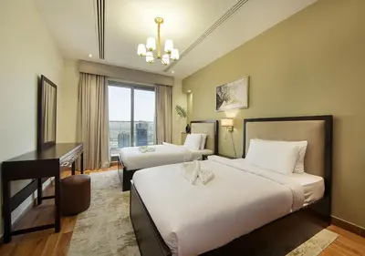 a hotel room with two beds and a desk at 2BR Chic Elite Suite in Downtown near Dubai Mall in Dubai