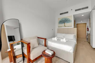 a living room with a white couch and a chair at Amazing Studio in Azizi Riviera 1 in Dubai