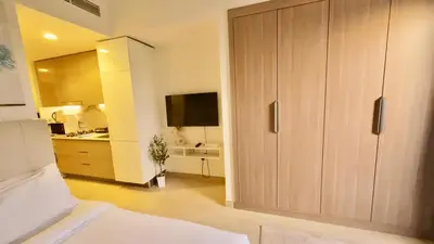 a kitchen with a large wooden cabinet in a room at Amazing Studio in Azizi Riviera 1 in Dubai