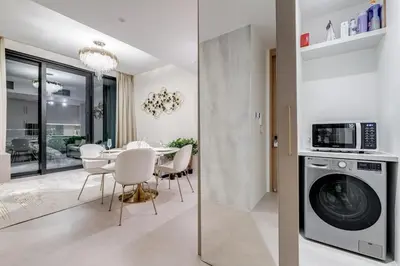a kitchen and dining room with a washing machine at ADDRESS Residences by Happy Season in Dubai