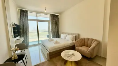 a hotel room with a bed and a chair and a window at Cosy Studio in Carson Tower C in Dubai