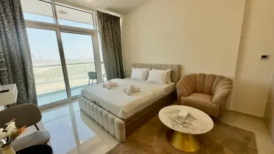 a hotel room with a bed and a chair and a table at Cosy Studio in Carson Tower C in Dubai