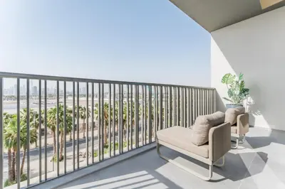 a living room with a balcony with palm trees at Studio with Glimpse of Burj Khalifa, Minutes from Downtown Dubai, MAG 930, Mohammad Bin Rashid City by Deluxe Holiday Homes in Dubai