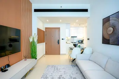 a living room with a white couch and a table at Bright 1BR in Binghatti House, Prime Location in Dubai