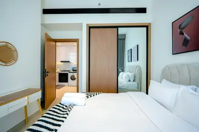 a bedroom with a white bed and a bathroom at Bright 1BR in Binghatti House, Prime Location in Dubai
