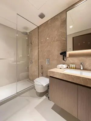 a bathroom with a toilet and a shower and a sink at Elegant and Stylish 1BR, Grand Blue in Dubai