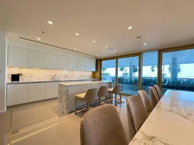 a kitchen with a long table and chairs at Elegant and Stylish 1BR, Grand Blue in Dubai