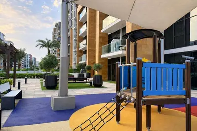 a blue playground in front of a building at TRPS - Azizi Riviera 23, Al Meydan - 2BR Elegant Apartment with Access to Premium Amenities in Dubai