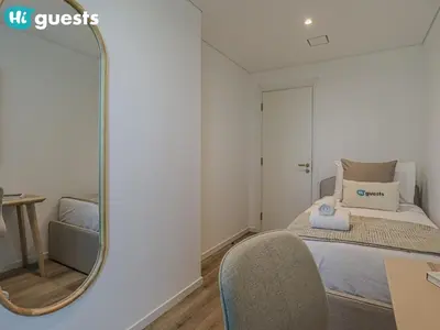 a bedroom with a mirror and a bed and a chair at HiGuests - Luxe 2BR Overlooking Golf Course & Greenery in Dubai