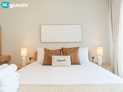 a bedroom with a white bed with two lamps at HiGuests - Luxe 2BR Overlooking Golf Course & Greenery in Dubai