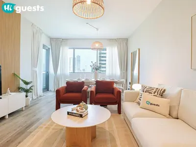 a living room with a couch and a table at HiGuests - Luxe 2BR Overlooking Golf Course & Greenery in Dubai