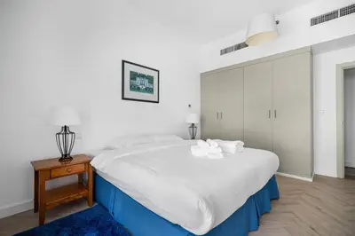 a bedroom with a large white bed and a night stand at Ain Vista - Rimal 5 - JBR in Dubai
