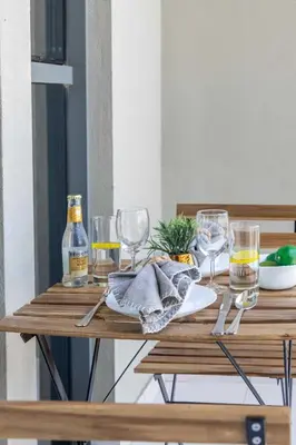 a wooden table with glasses and a bottle of wine at Frank Porter - Midtown By Deyaar - Dania 2 in Dubai