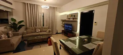 a living room with a couch and a table and a television at JLT 1BR Marina Skyline View in Dubai