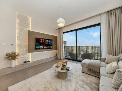 a living room with a couch and a large window at Contemporary Parkfront 2BR Dubai Hills Living in Dubai