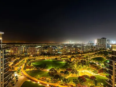 a view of a city at night at Contemporary Parkfront 2BR Dubai Hills Living in Dubai