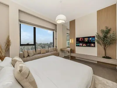 a bedroom with a large white bed and a large window at Contemporary Parkfront 2BR Dubai Hills Living in Dubai