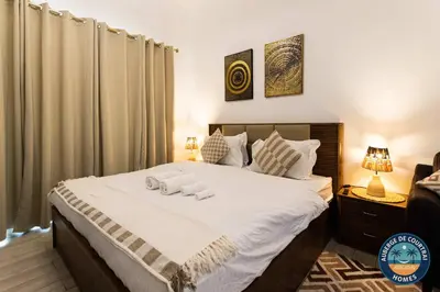 a bedroom with a bed with two towels on it at Modern Studio Fully Furnished Oxford Residence in Dubai