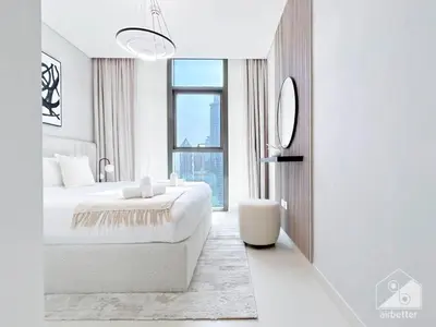 a white bedroom with a bed and a window at Full Luxury at Burj Crown 2B with City Views in Dubai
