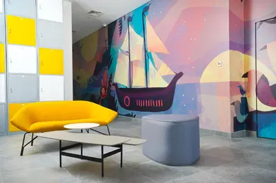 a yellow chair and a table and a colorful wall at YouCo Dubai apart-hotel in Dubai