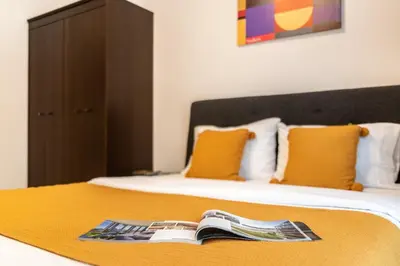 a hotel room with a bed with a magazine on it at YouCo Dubai apart-hotel in Dubai