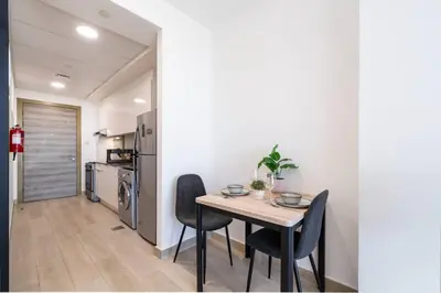 a kitchen and dining room with a table and chairs at Luxury JVC Studio in a Great Location in Dubai