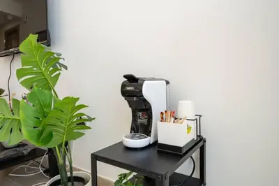 a sewing machine sitting on a table next to a plant at Luxury JVC Studio in a Great Location in Dubai